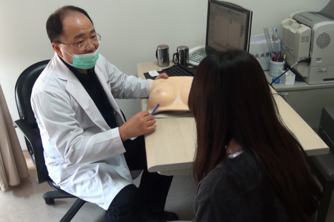 近來流行自體脂肪豐胸，但手術仍有風險。圖為醫師正為一名年輕女子解說隆乳手術情形。(本報資料照片)

