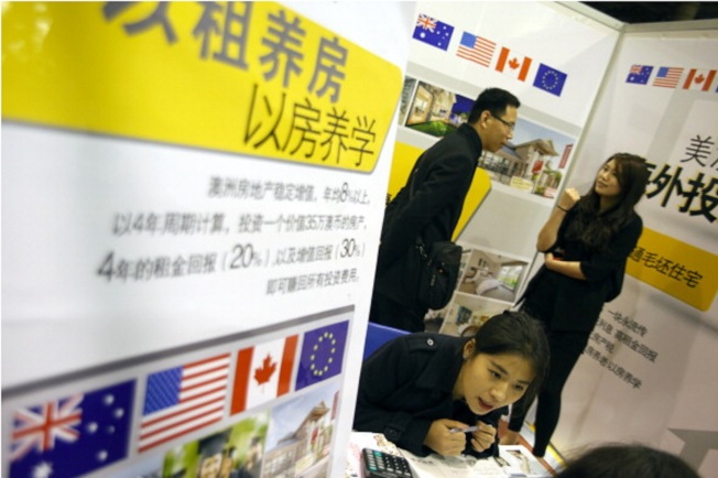 经济学人报导,中国留学生父母已成为拉高美国大学城房地产行情的主力。图为2014年一场在中国青岛针对留学生父母举办的房产销售会。(Getty Images)