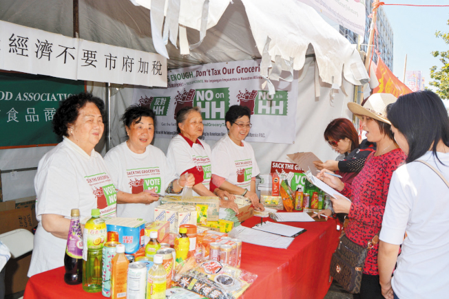 街會上發放資料,告知市民屋崙11月公投的汽水稅真相,透過簽名方式反對汽水稅。(記者劉先進/攝影)