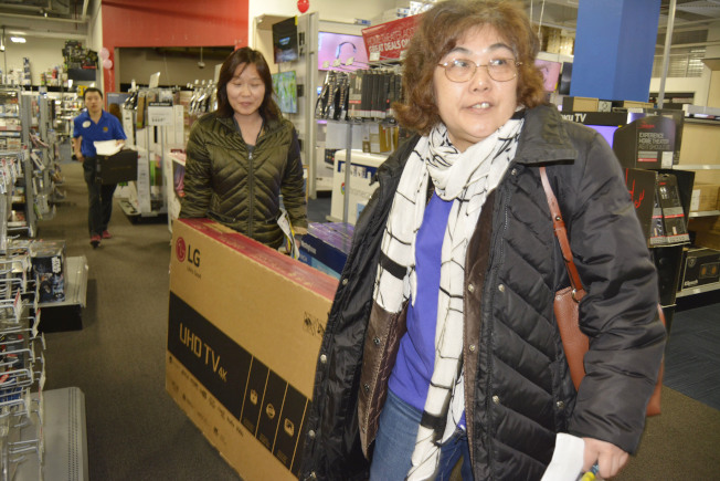 华人顾客冲进百思买店内，立刻扛走一台大电视。(记者俞姝含/摄影)