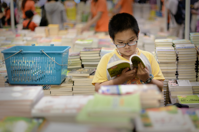 專家建議在為孩子挑選書籍時,最好能考慮孩子興趣的前提下挑一些內容對他們有挑戰性的。(Getty Images)