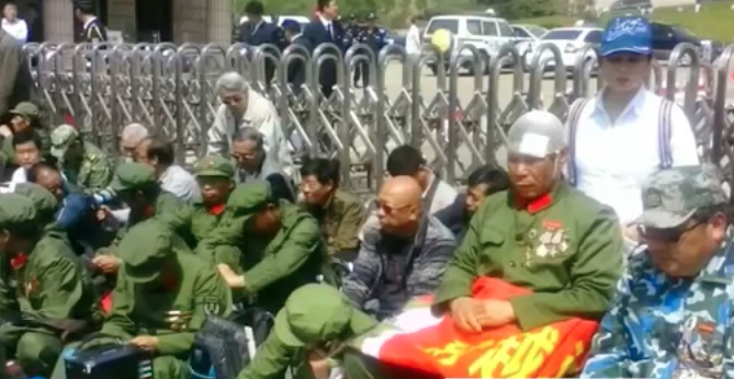 网上视频显示，近日不断有退役军人搭火车涌入镇江，他们身穿迷彩服，拿着五星旗，叫着“改善老兵生活”口号。（视频截图）