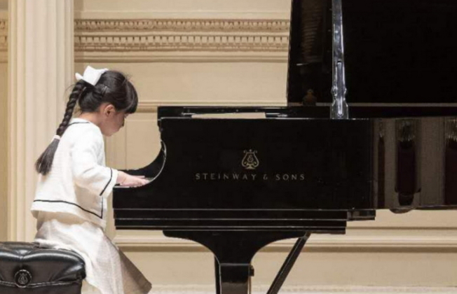 7歲的鋼琴小神童黃以欣(Abigail Huang)贏得2019年國際大師鋼琴和弦樂比賽(2019 International Maestro Piano and String Competition)18歲組第二名,在得獎人音樂會中演奏。(王蔚蔚提供)