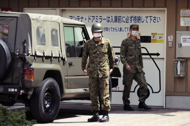 7日協助緊急事態防疫工作的日本自衛隊。根據日本中央政府的宣布措施,緊急事態下的大眾交通運輸能維持正常運轉,同時公共安全以及防災體系(氣象廳、警察、消防和自衛隊等),除了部分已進行在家工作的內勤人員外,都還是維持著24小時運轉。(Getty Images)